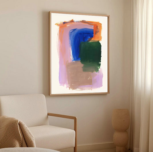Abstract painting on a wall above a white armchair in a room with neutral decor.