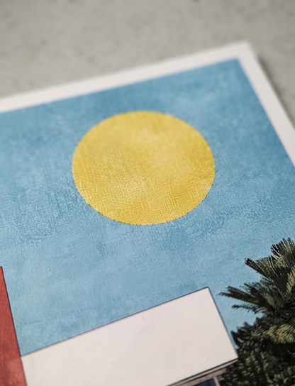 A close-up of a square Bauhaus style swimming pool architectural print with modernist pool house featuring a textured light blue background with a large textured yellow circle, photographed on a neutral gray surface.