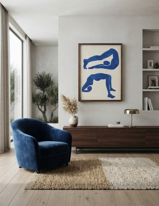 A modern living room scene featuring a blue velvet armchair, a dark wood console table, a woven rug, and a framed PrintHaus Contemporary Blue Abstract Figurative Wall Art Poster inspired by Matisse