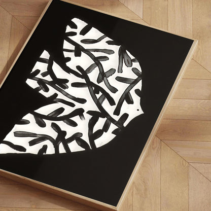 Black and white abstract design on a black mat on a wooden floor