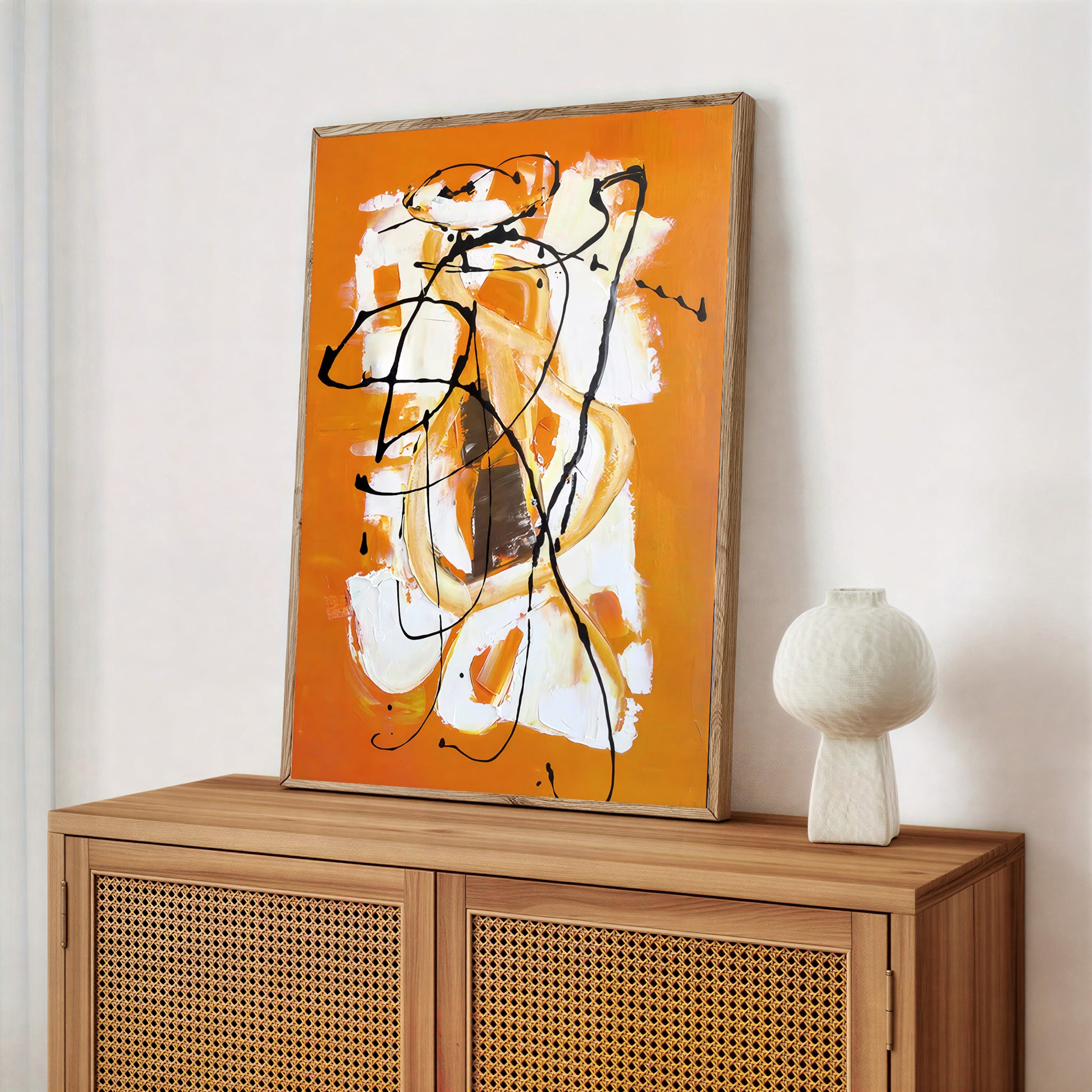 Abstract painting on a wooden cabinet with a white vase.