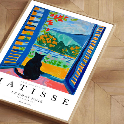 Framed Matisse print of a cat by a window on a wooden floor