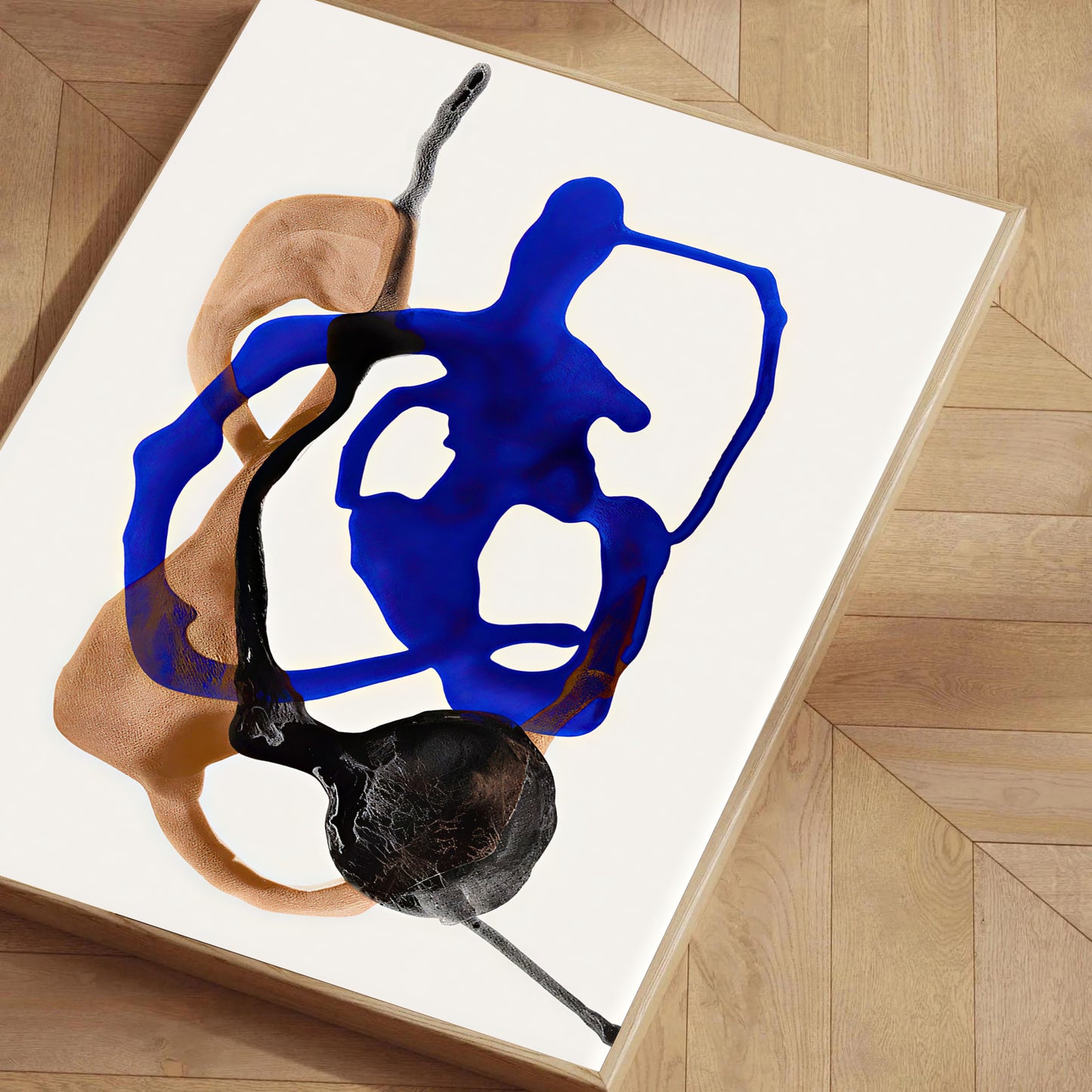 Abstract artwork with blue and black shapes on a white background, displayed on a wooden floor.
