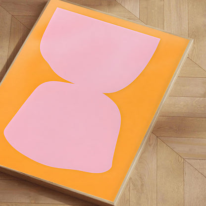 Pink abstract design on an orange rug on a wooden floor