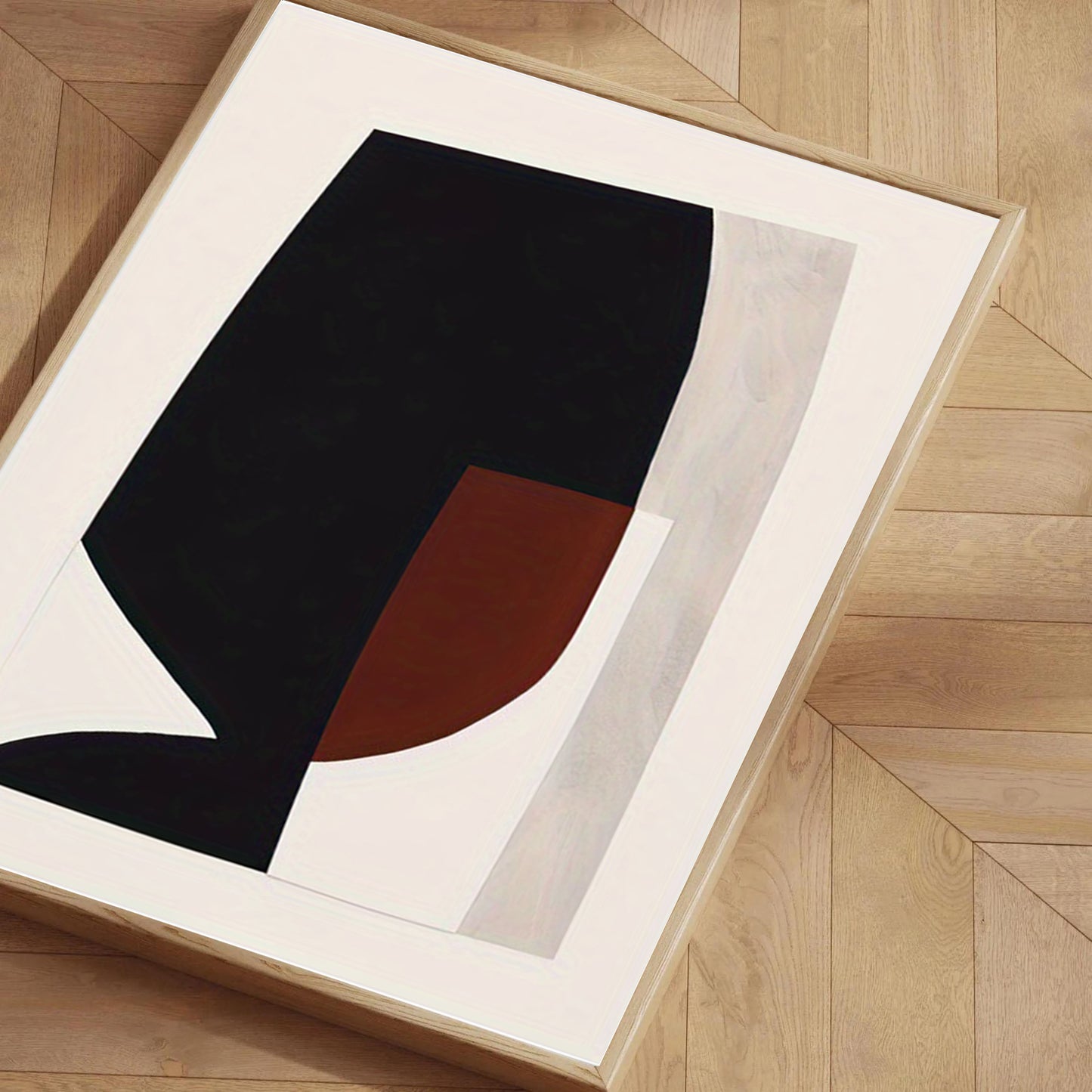 Abstract art print with black and red shapes on a beige background, framed in a white frame.