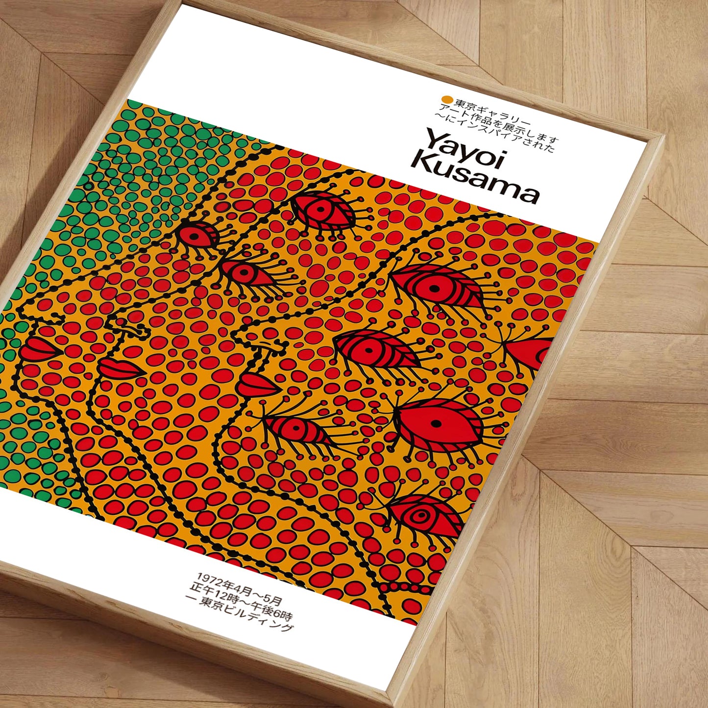 Framed poster inspired by Yayoi Kusama featuring colorful dotted abstract faces in red, yellow, and green, placed on a wooden floor