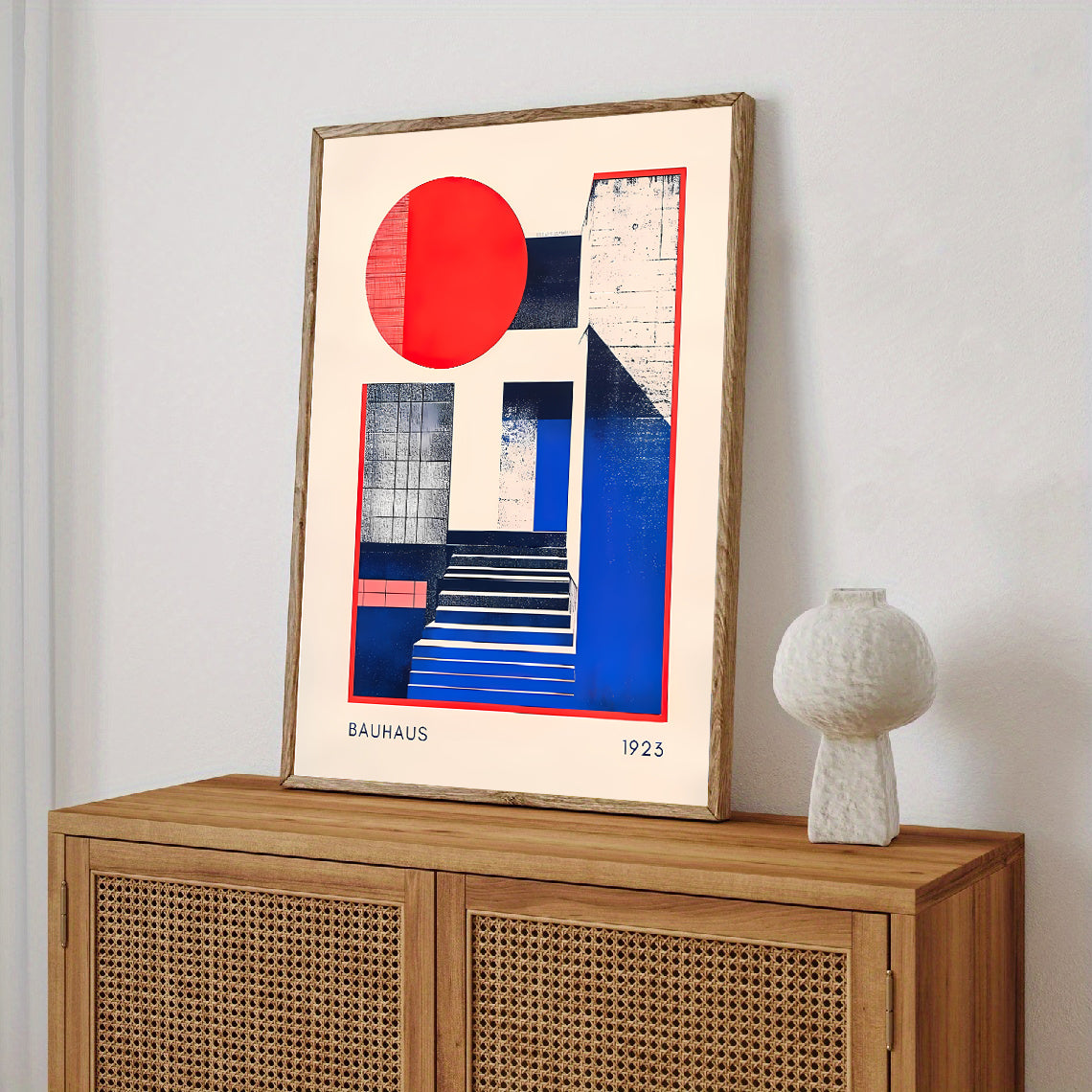 Framed abstract art piece on a wooden cabinet with a white lamp.