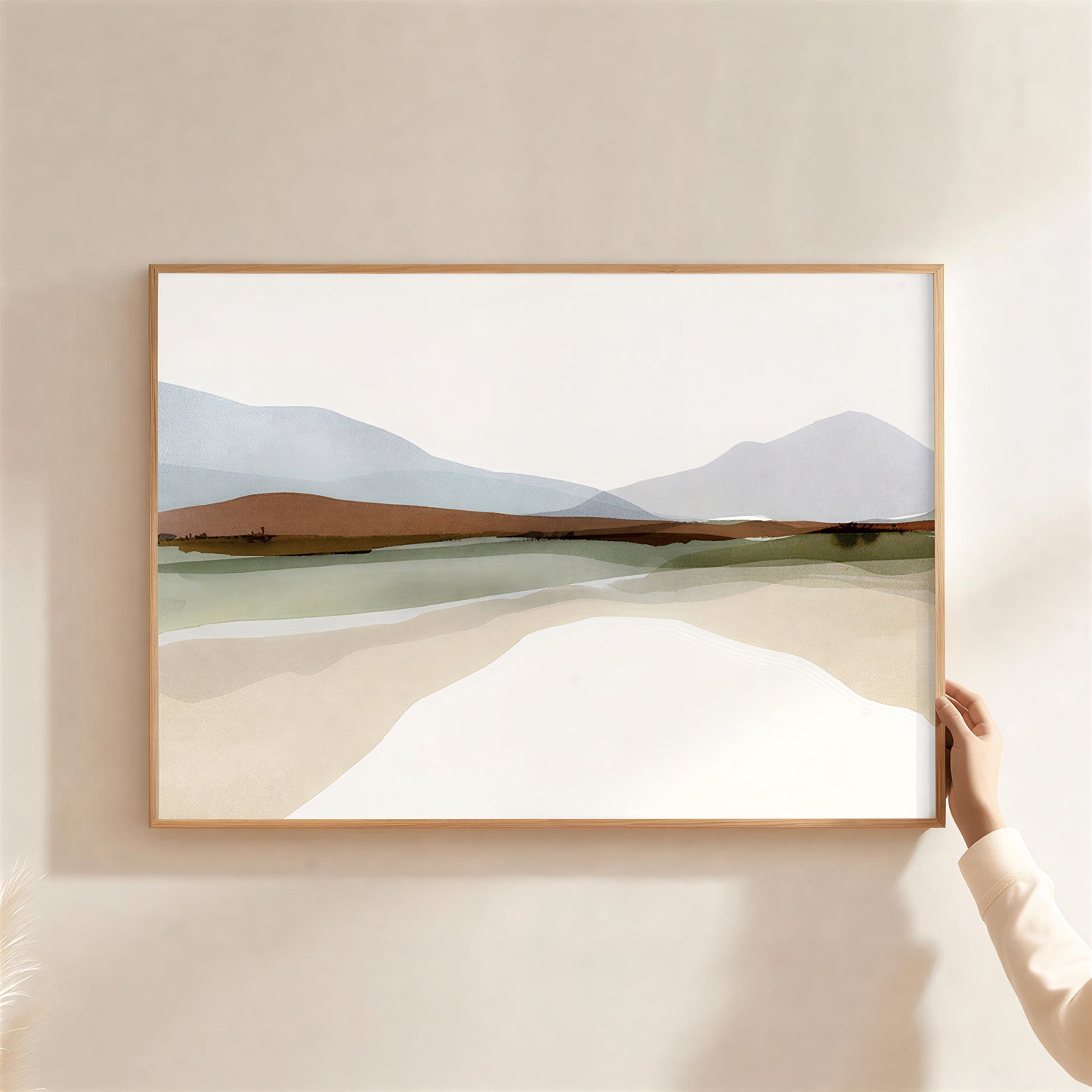 Framed landscape painting of a desert scene with mountains on a beige wall.