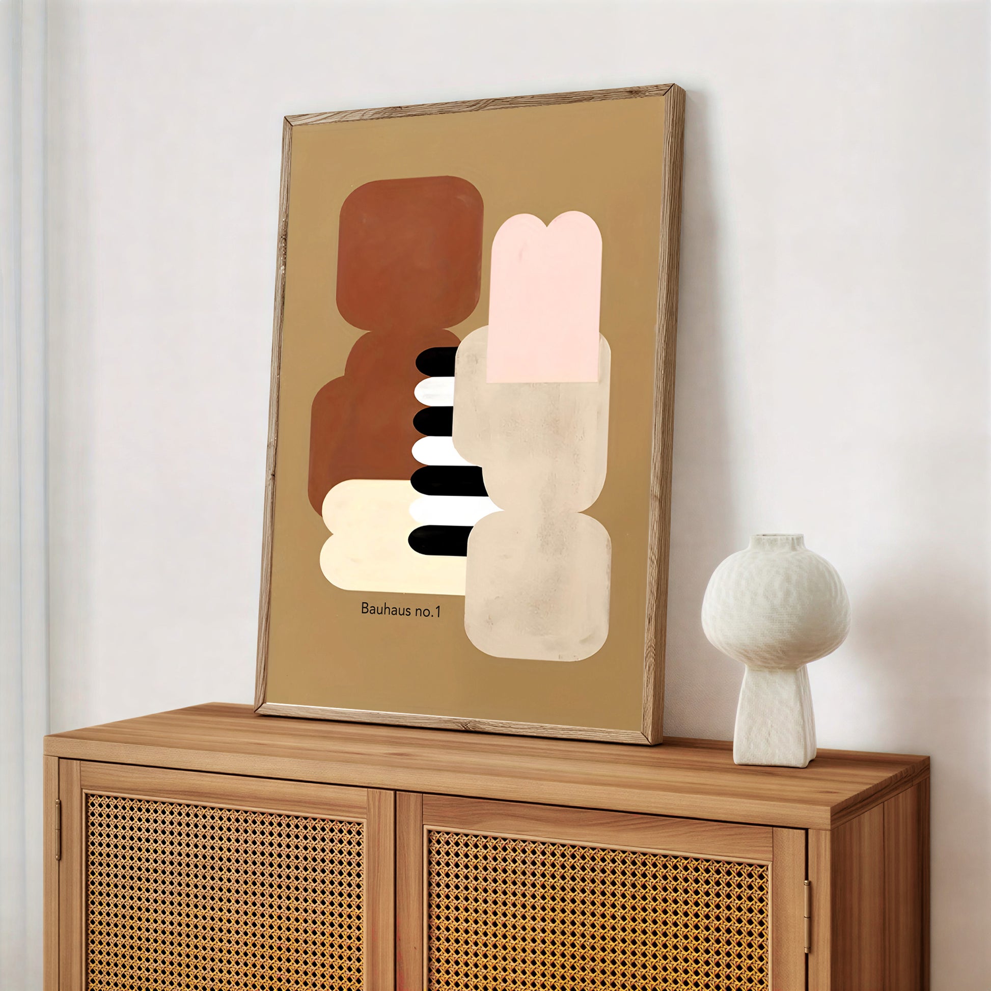 Abstract art piece on a wooden cabinet with a white vase.
