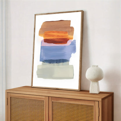 Abstract art piece on a wooden cabinet with a white vase.