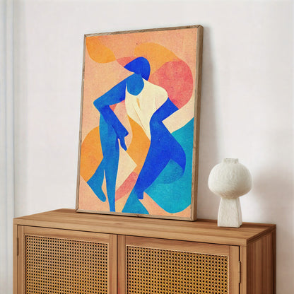 Framed abstract artwork of two blue figures on a wooden cabinet with a white vase.