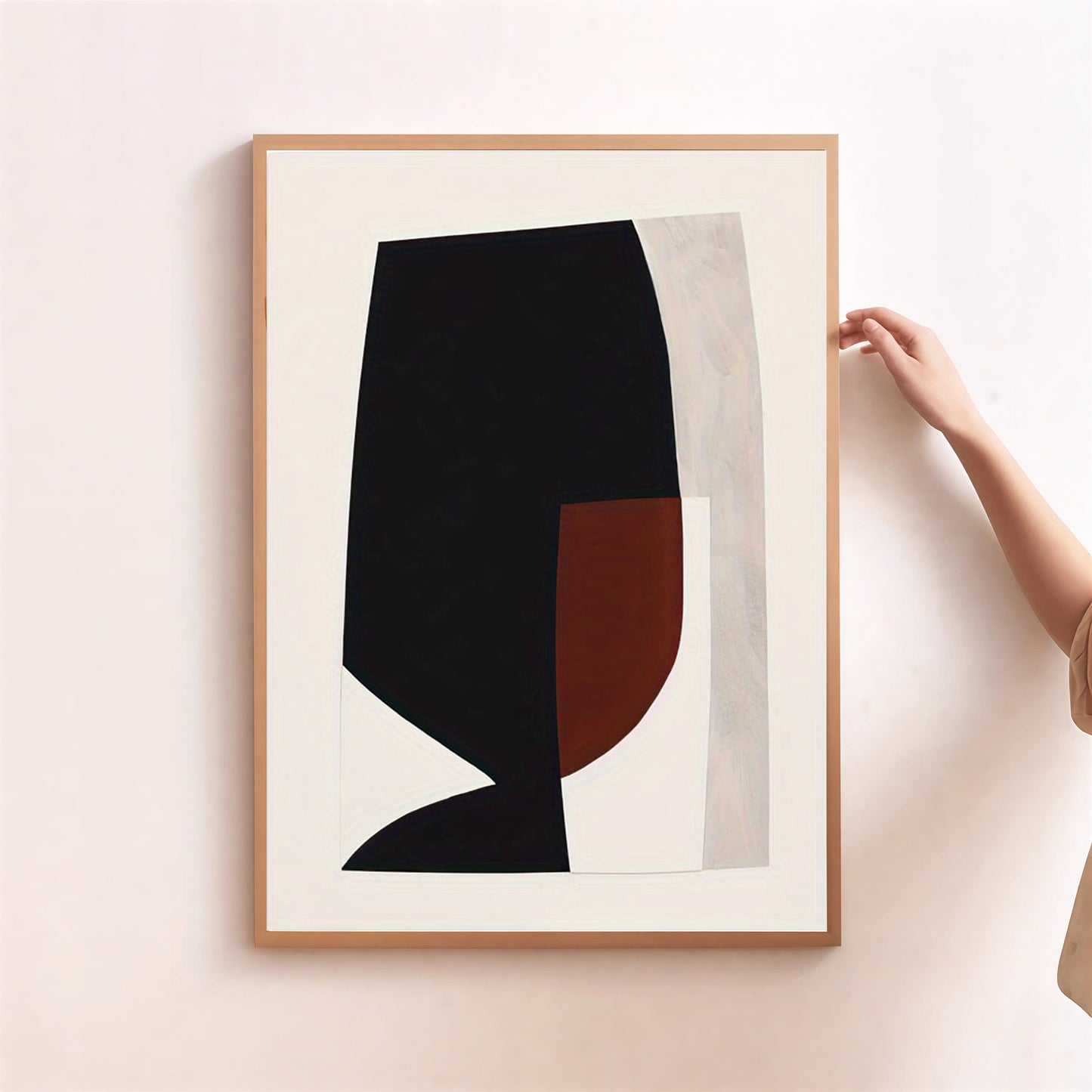 Framed abstract art piece with black and brown shapes on a light background