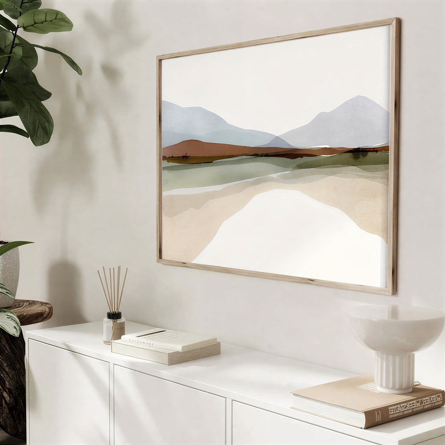 Framed landscape painting on a wall with decorative items below
