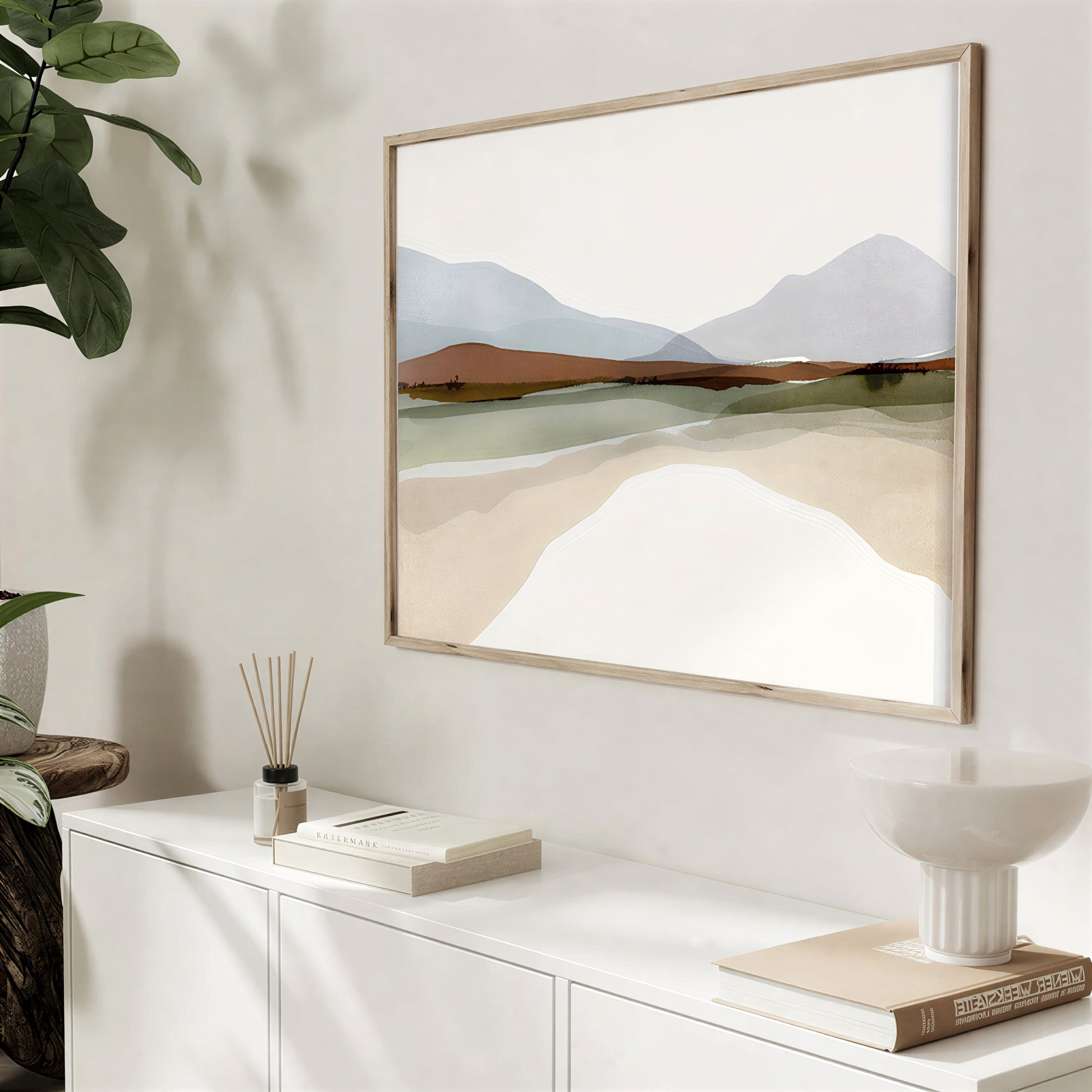 Framed landscape painting on a wall with decorative items below