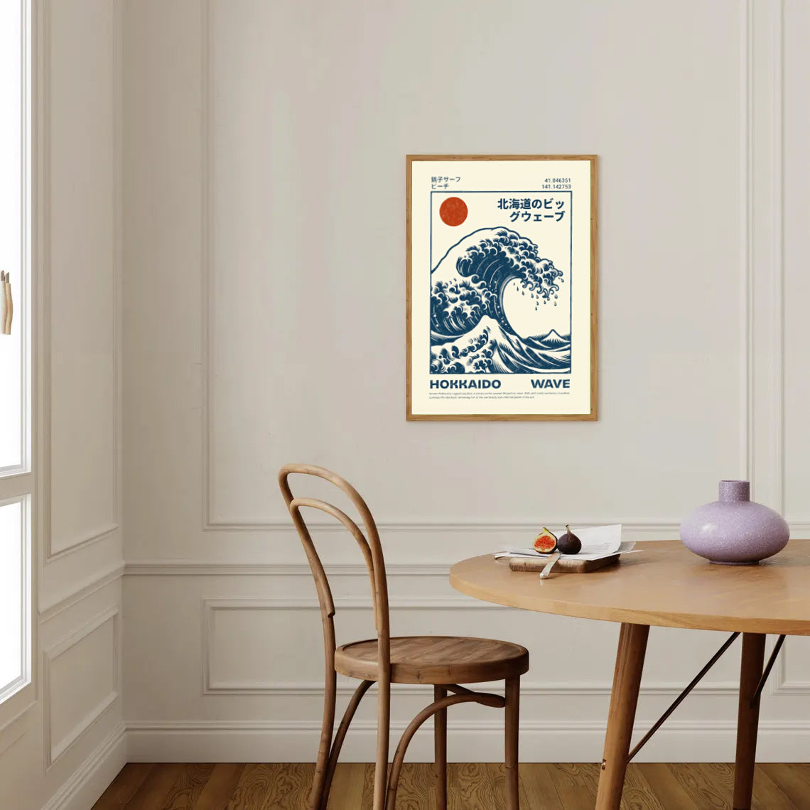 Framed artwork of Hokusai Wave Poster Print design on a wall above a wooden table and chair.