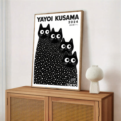 Framed Yayoi Kusama cats poster with black cat illustration on a wooden cabinet.