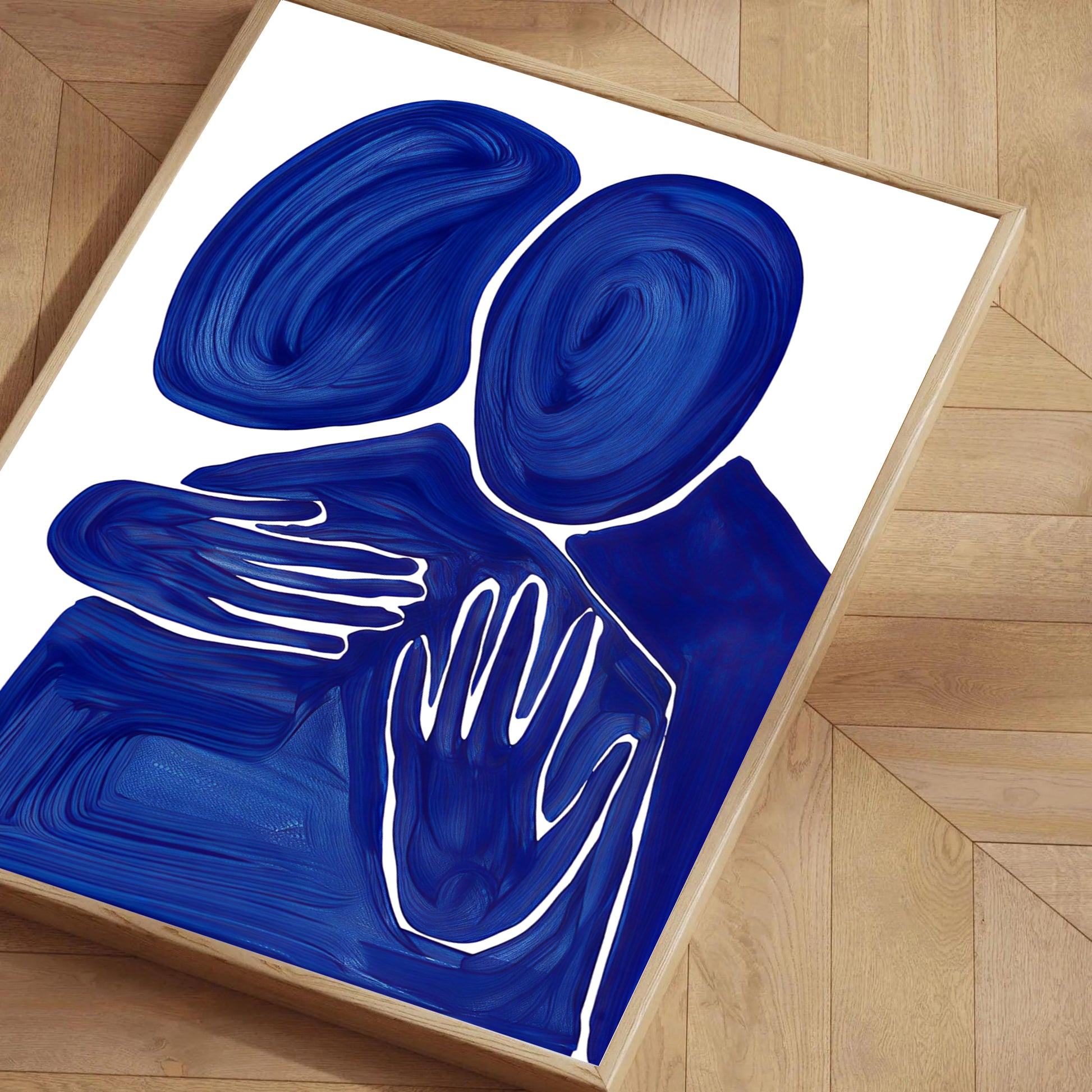 Blue abstract art with hand shapes on a white background, framed in a wooden frame.