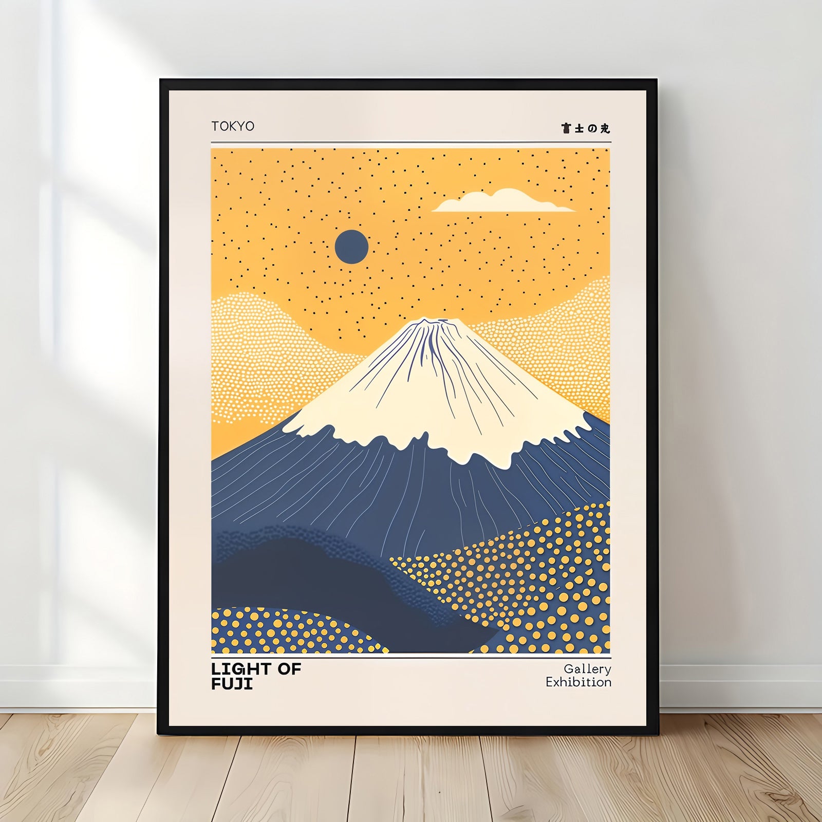 Framed artwork of Mount Fuji with a blue sky and orange sun, labeled 'Light of Fuji' on a white wall.