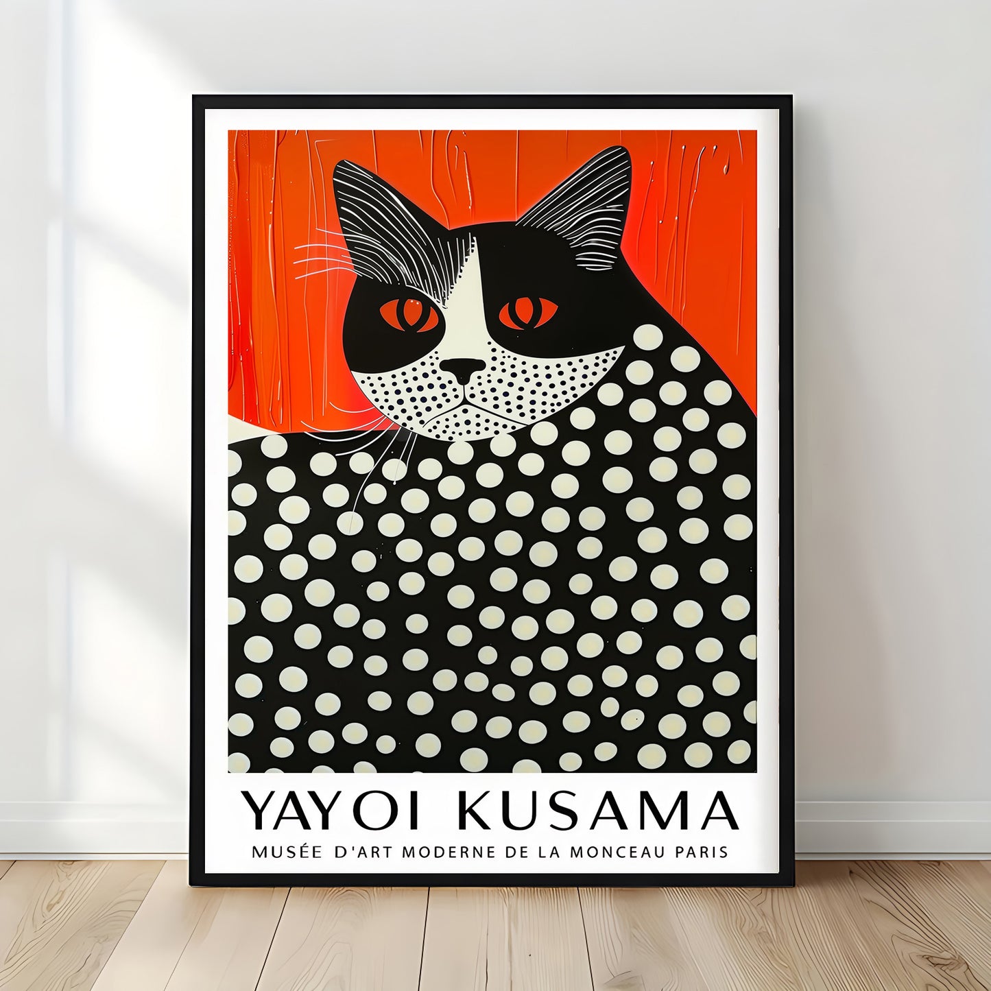 Contemporary black-framed Yayoi Kusama-inspired cat print with red-orange backdrop and dotted pattern, standing against a light grey wall on wooden flooring