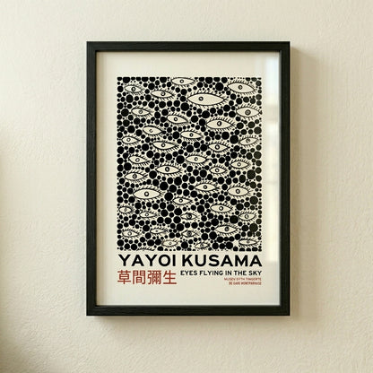 Framed Yayoi-Kusama Inspired Poster Dots and Eyes on a beige wall.