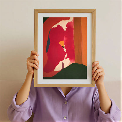 Person holding a framed abstract art print with a colorful design.