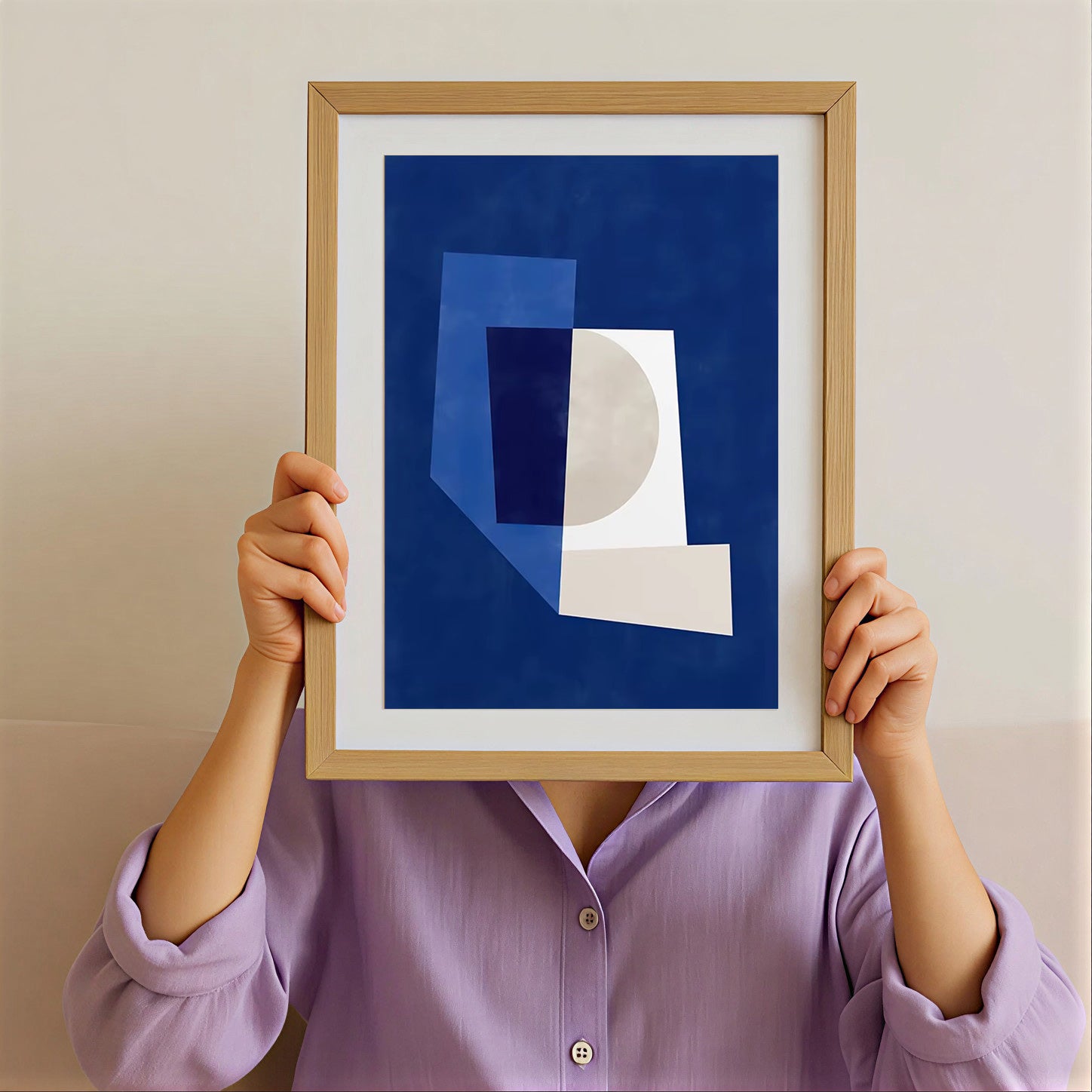Person holding a framed abstract art piece with geometric shapes against a plain background