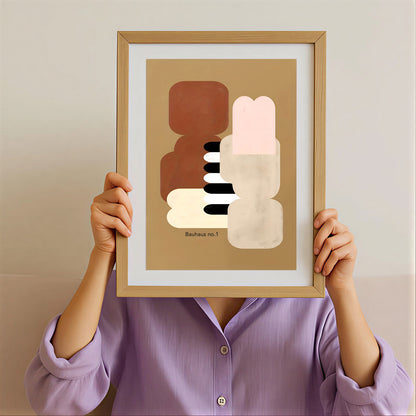 Person holding a framed abstract art print against a plain background