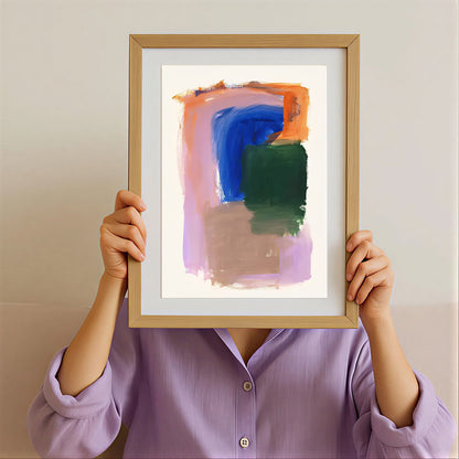 Person holding a framed abstract art print with a neutral background