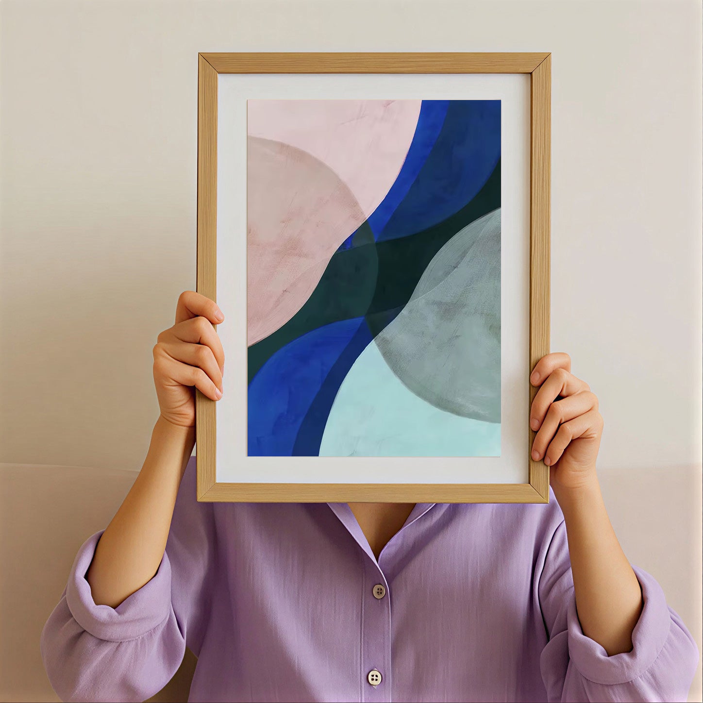 Person holding a framed abstract art print with a neutral background