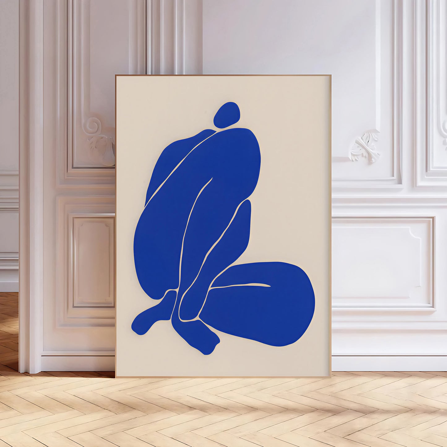 Abstract art print with blue figure on beige background in a room with wooden floor and white walls.