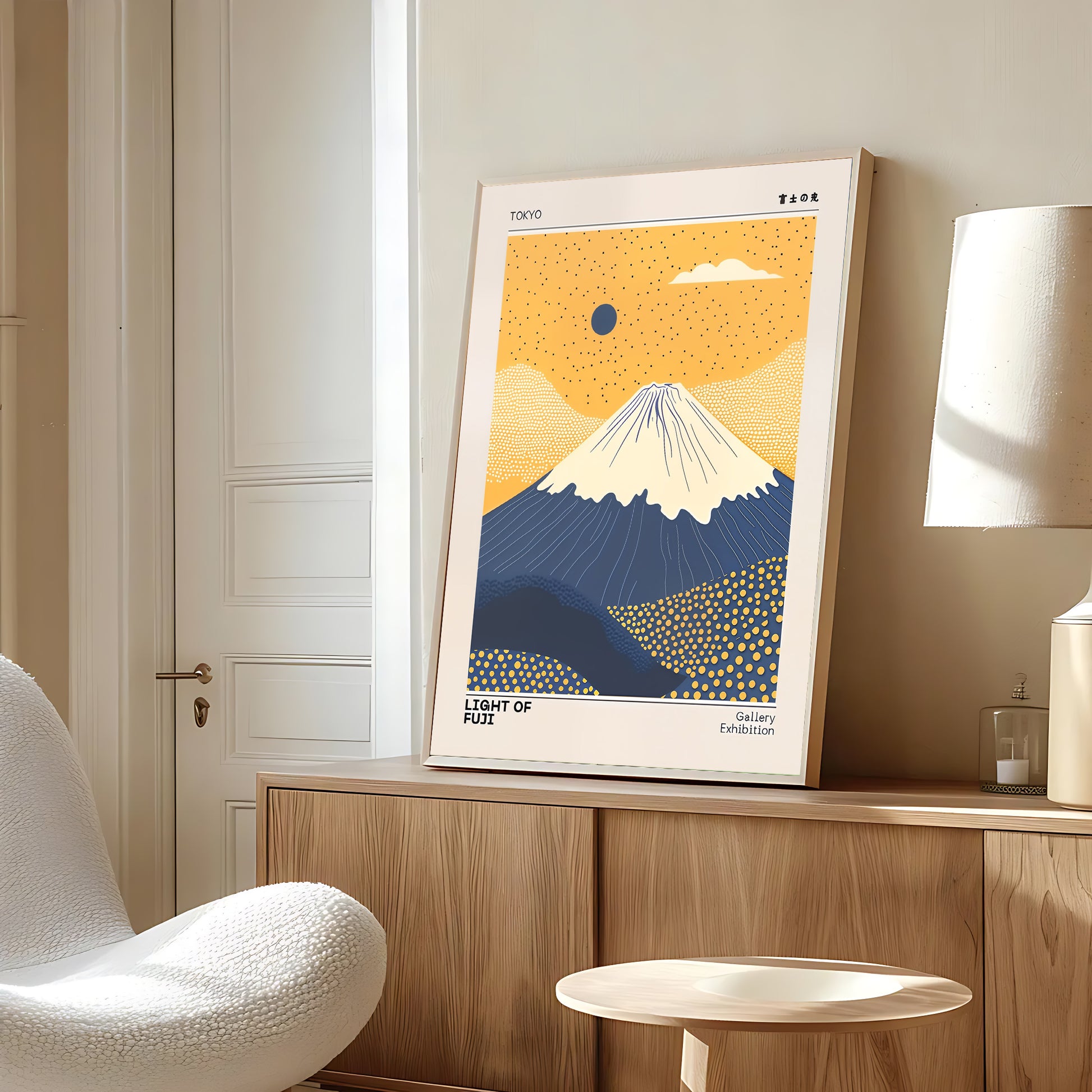 Framed artwork of a mountain on a wall in a room with a chair and lamp.
