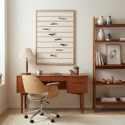A framed  Minimalist Swimming Pool Art Print featuring modern pool illustration wall décor, featuring horizontal blue stripes and small flying fish on a cream background, displayed above a mid-century modern wooden desk with a matching swivel chair in a styled room.