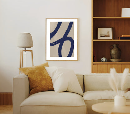 Living room with a beige sofa, abstract art on the wall, and wooden shelves.