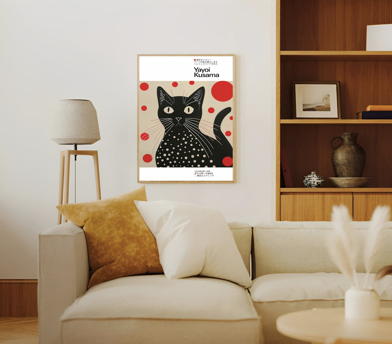 Living room with a beige sofa, yellow pillow, white lamp, and a framed picture of a Yayoi kusama inspired black cat art print with polka dots.