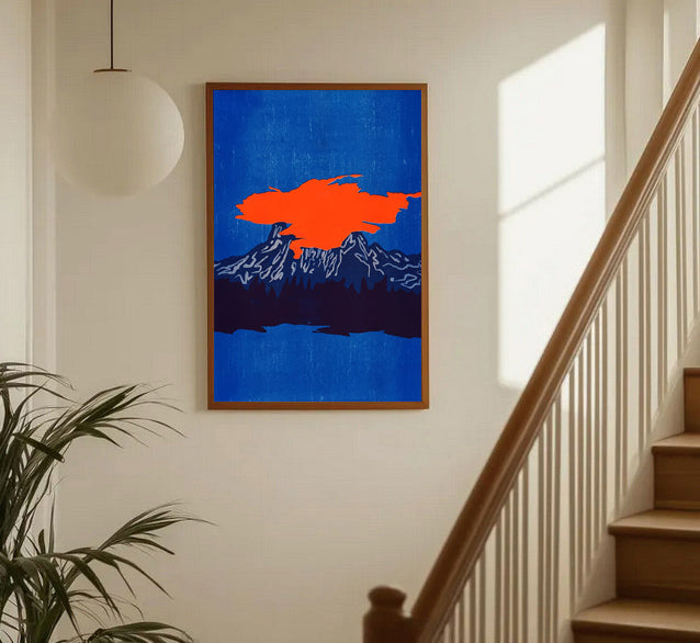 Framed artwork with a red abstract shape on a blue background in a home setting.