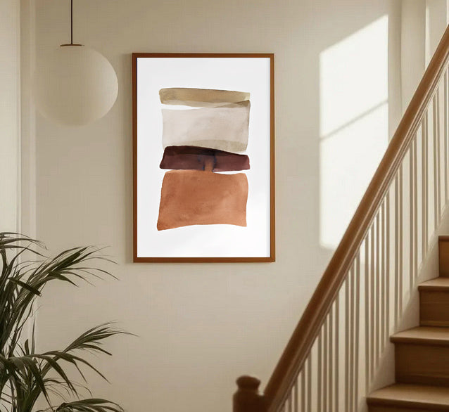 Abstract art print in a wooden frame on a wall above a staircase