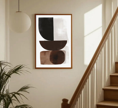 Abstract art piece on a wall in a home setting with a staircase and plant.