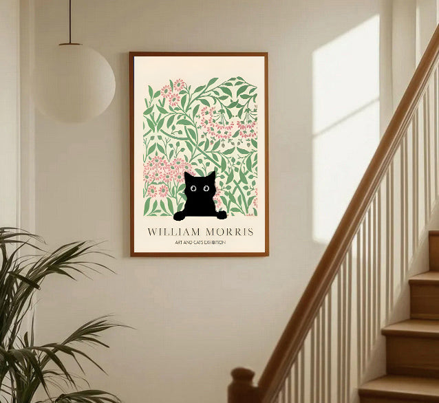 Framed artwork with a black cat art print with floral design on a wall near a staircase.