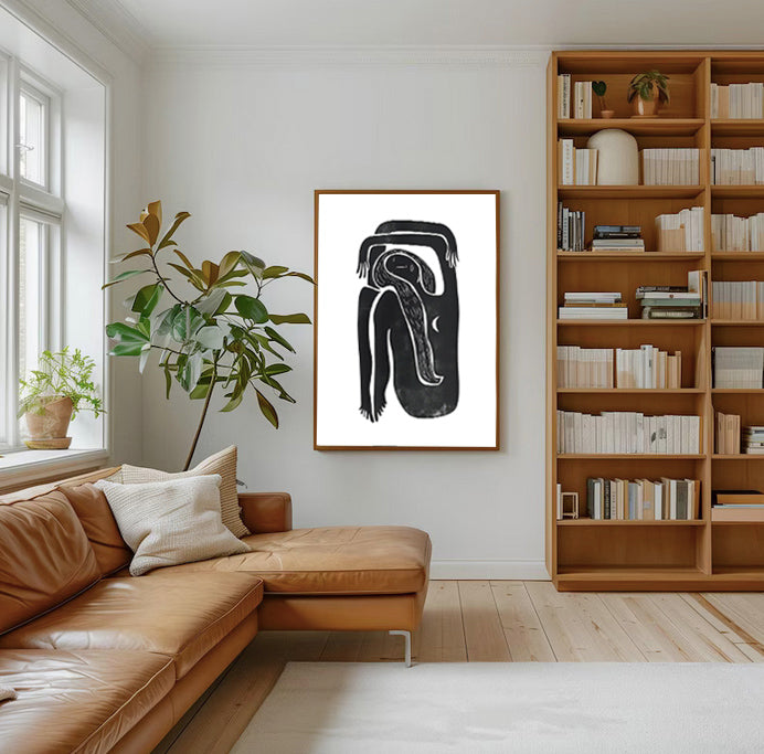 Modern living room with a brown leather sofa, bookshelf, and abstract art on the wall.