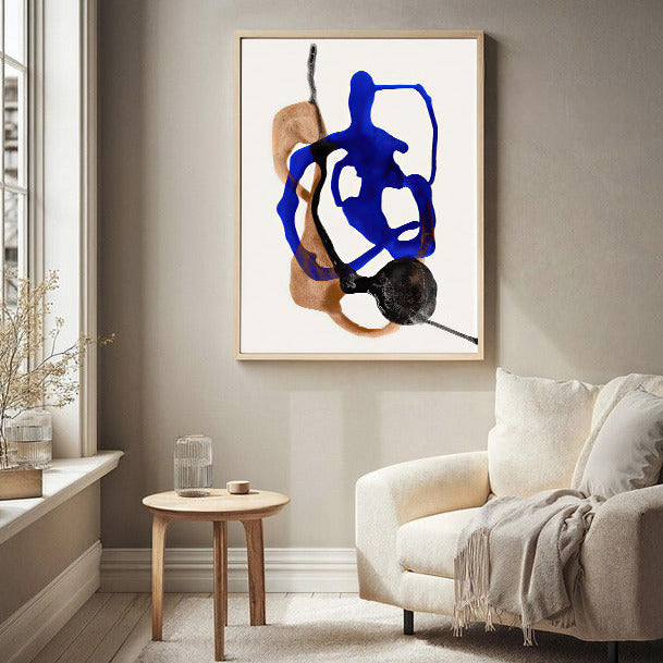 Abstract art piece on a wall in a living room with a sofa and side table.