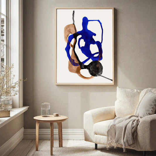 Abstract art piece on a wall in a living room with a sofa and side table.