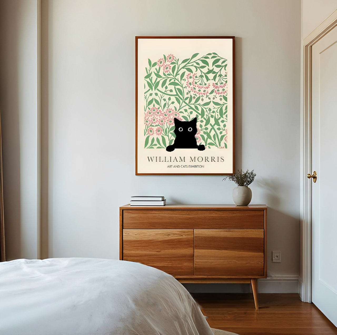 Framed artwork with a black cat art print with floral design on a wall above a wooden dresser.