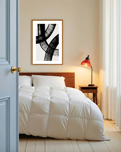 Bedroom with white bedding, wooden headboard, and abstract art on the wall.