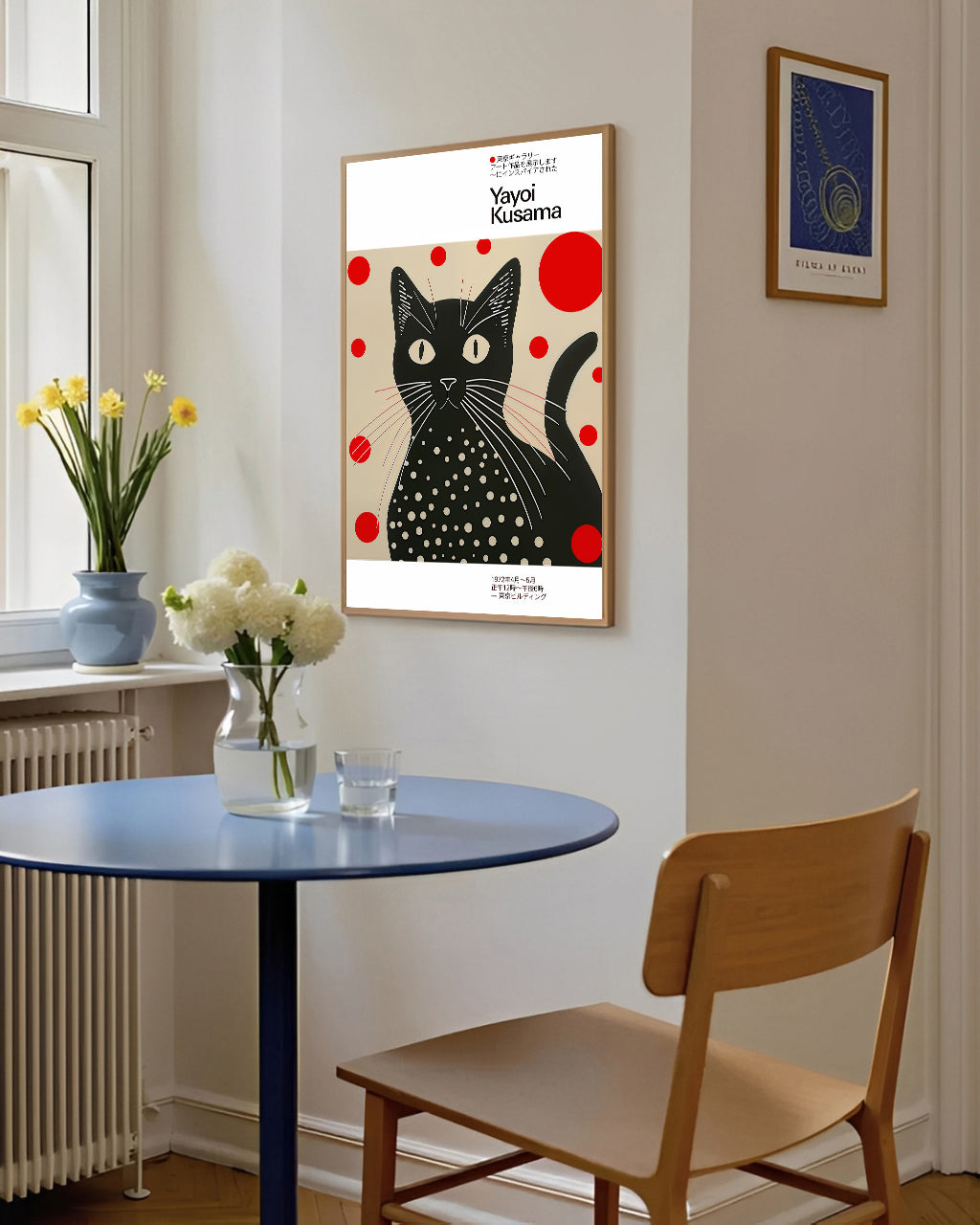 Dining room with a table, chair, and framed artwork of a black cat with red dots on a white background.