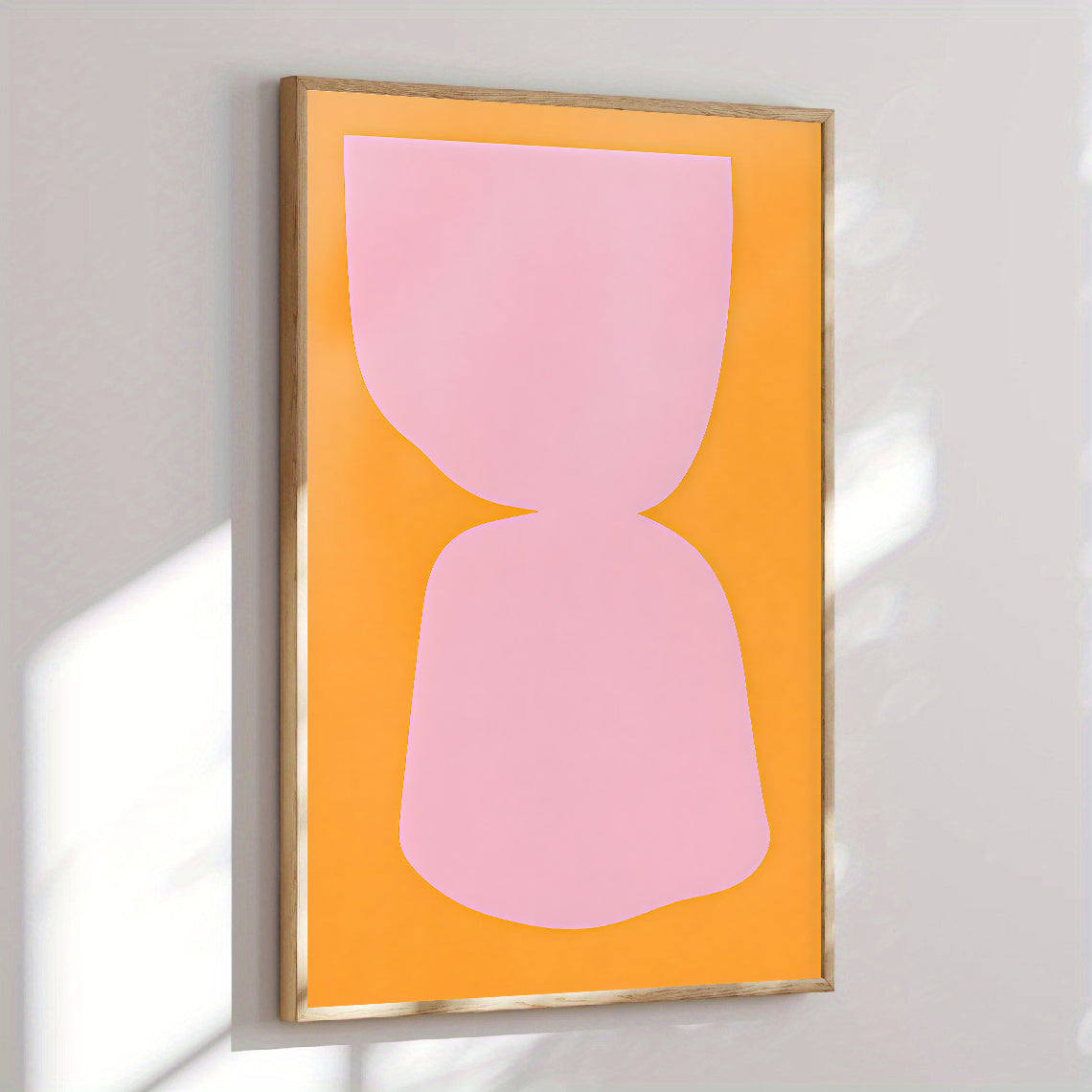 Framed abstract art with pink shape on orange background