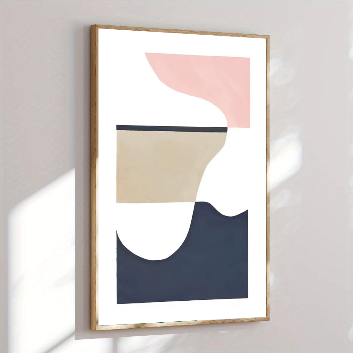 Abstract art print with geometric shapes in pink, beige, and navy on a white background, framed in gold.