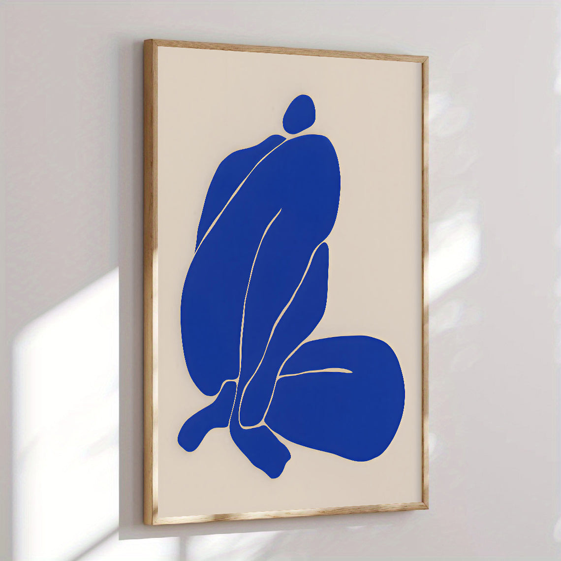 Framed abstract art with blue figures on a beige background