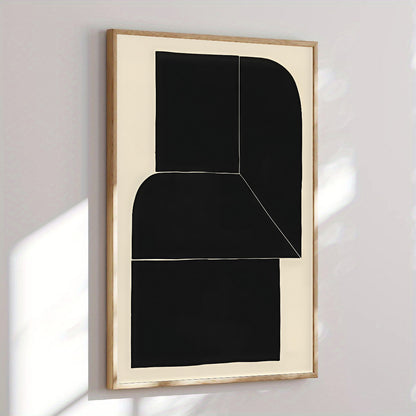 Abstract black and white artwork in a gold frame on a light gray wall
