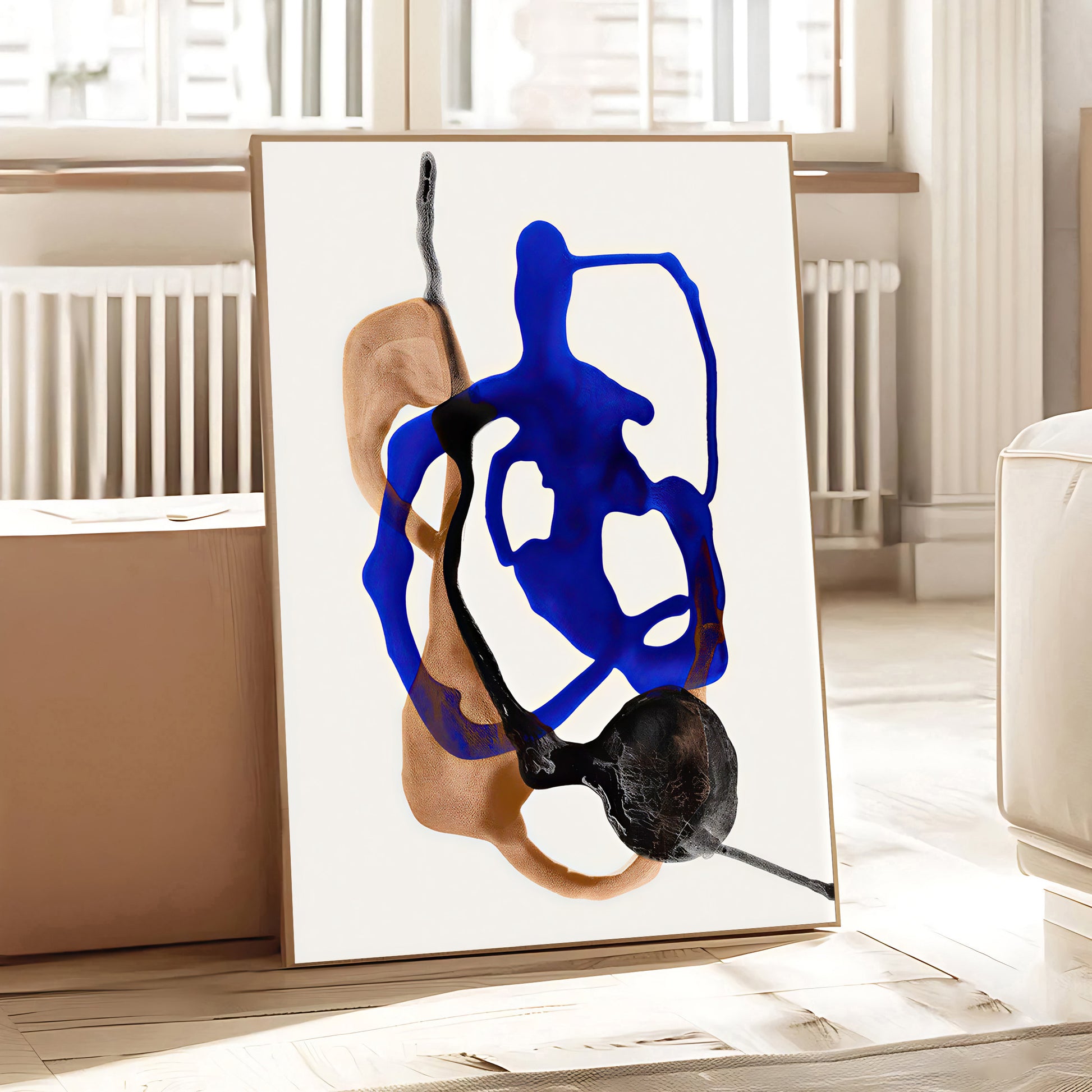 Abstract art piece with blue and black shapes on a white background, displayed in a room.
