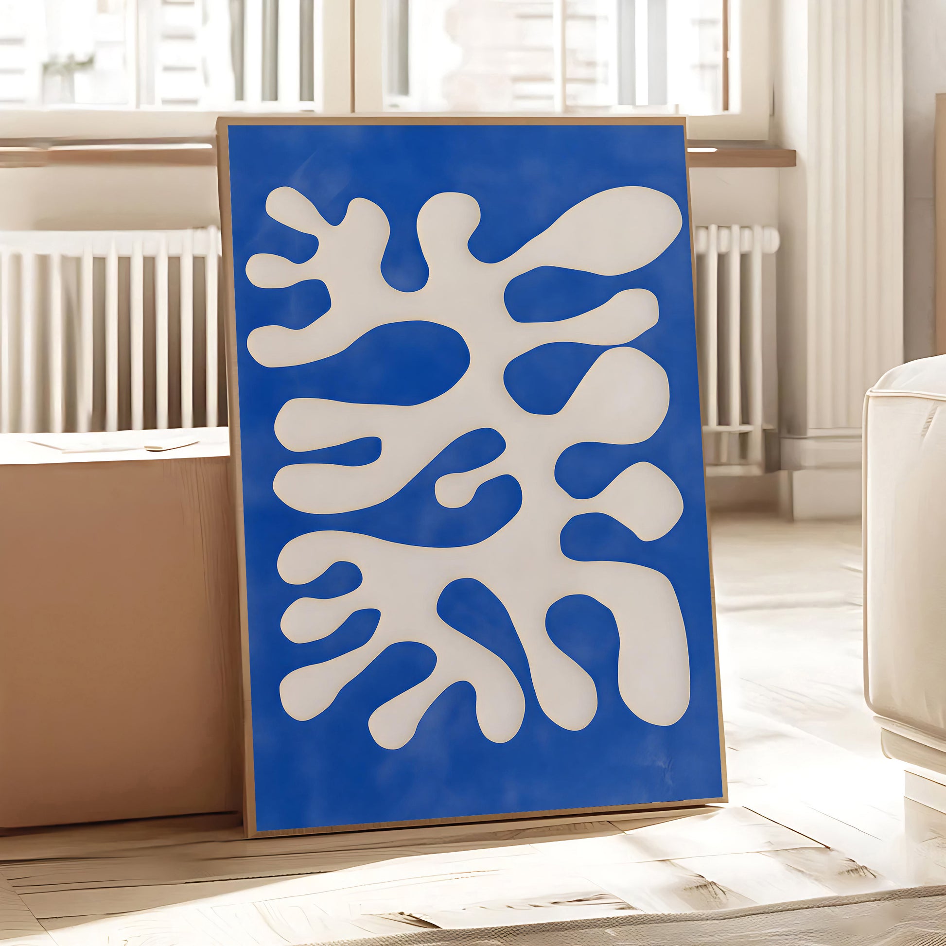 Abstract art piece with blue and white design on a wooden floor.